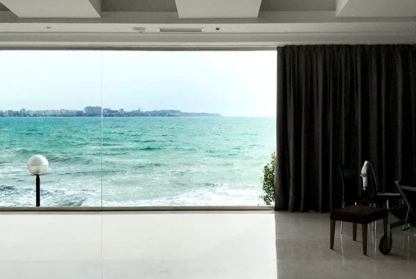 Modern living room interior with floor-to-ceiling windows overlooking the ocean.