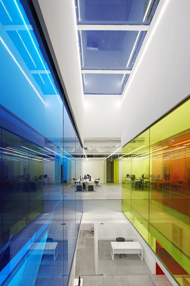 Modern office interior with colorful painted glass panels and open workspace