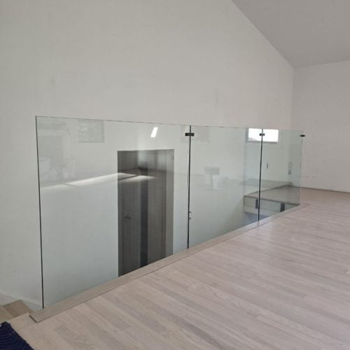 Transparent glass railing on the second floor in a modern interior