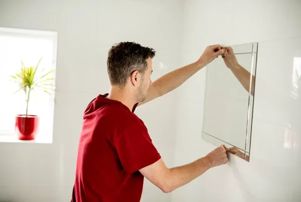 man hanging a mirror